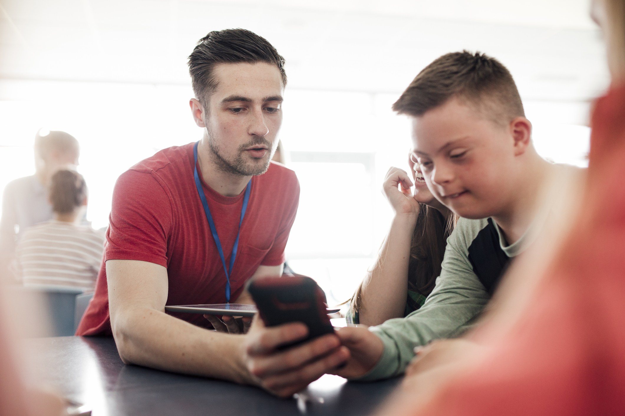 A male teacher with a male teen with down syndrome in the classroom
