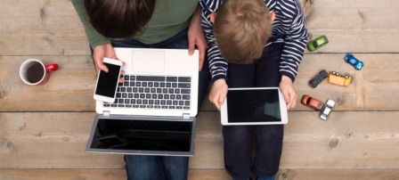 Overhead shot of a child and parent on their devices