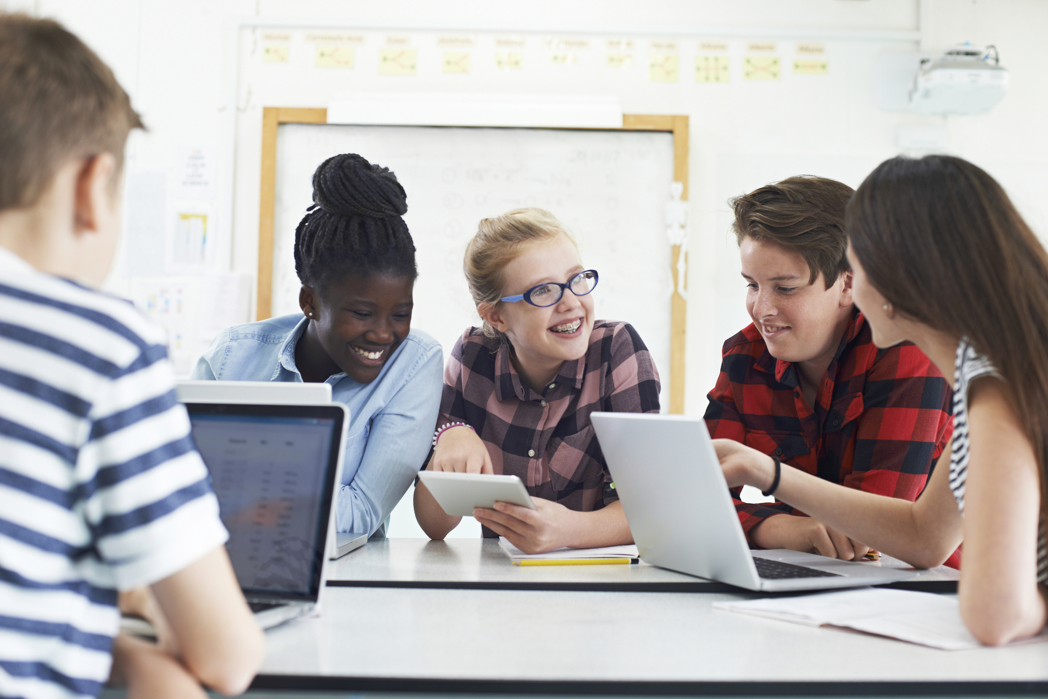 A group of students at computers engaged in conversation