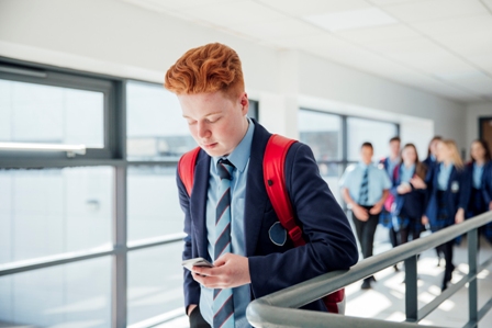 Boy in school uniform with cellphone