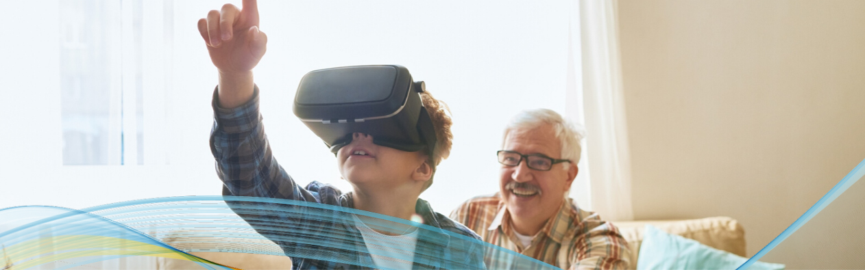 Child using VR headset with grandfather in background