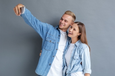 A teenage boy and teen girl take a selfie