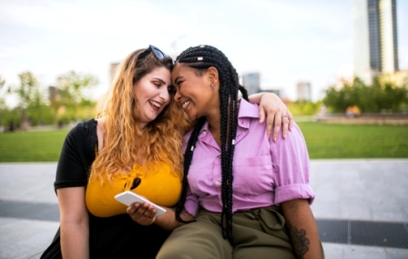 Two teen girls, hugging, smiling