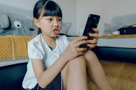 An Asian girl texting on her smart device