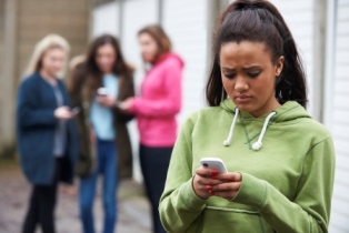 Girl looking at phone with girls in the background